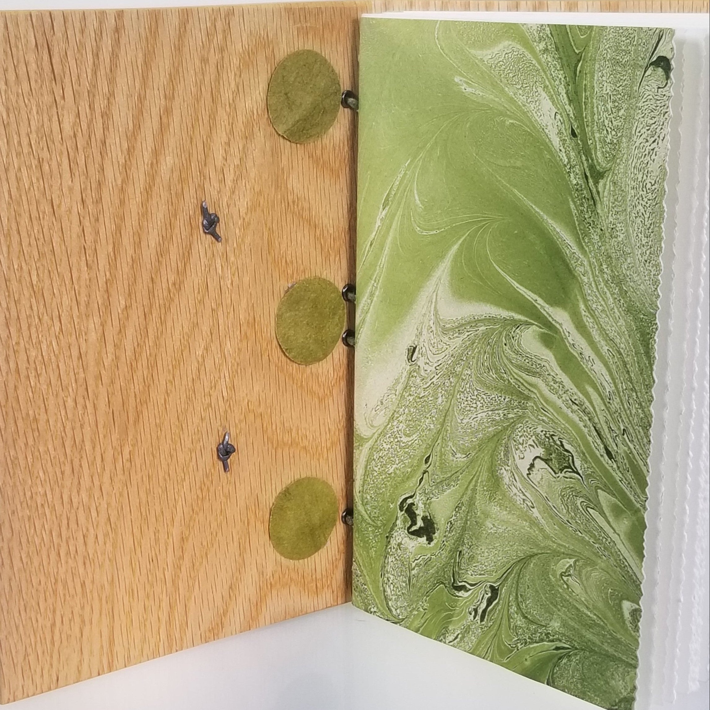 Open journal with wood cover, green marbled endpaper, pages with deckled fore edges
