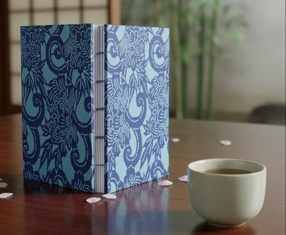 The same book reimagined in a computer-generated environment with petals scattered on the table, a cup of tea nearby, and a bamboo plant in the background behind a shoji screen.