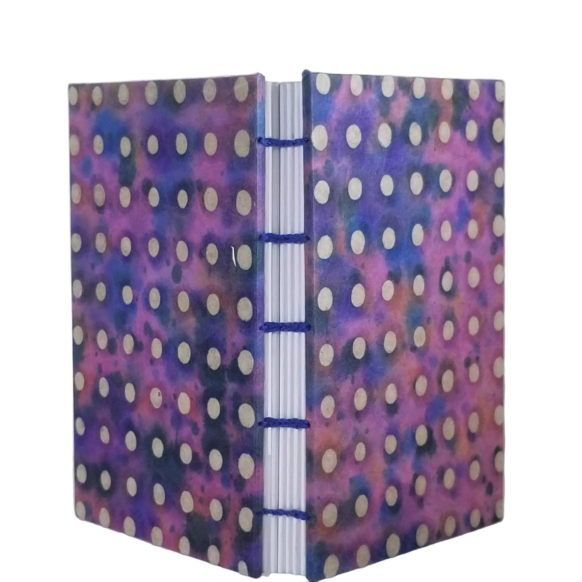 Handmade journal with purple/blue covers that have an abstract design of beige polkadots; six signatures of white drawing paper; and coptic-bound with waxed linen thread. ~4×5.5" and 116 pages
