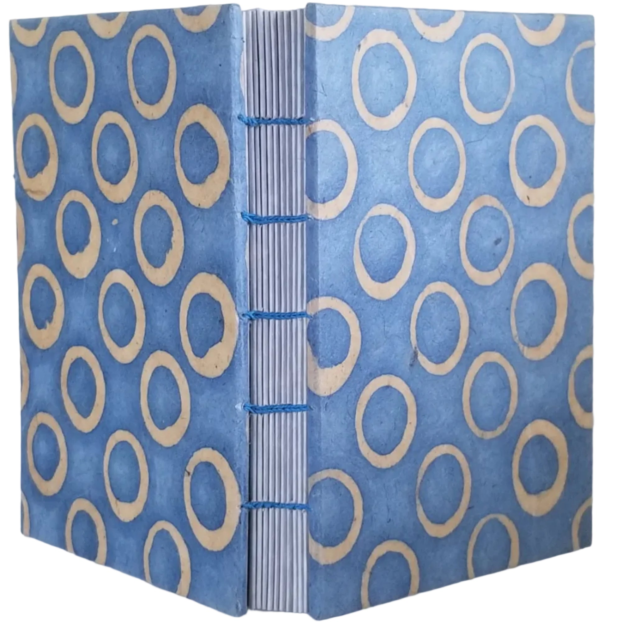 Handmade journal with light blue covers that have an abstract design of circles; twelve signatures of faux-gray parchment paper; and coptic-bound with matching thread. ~4×5.5" and 188 pages