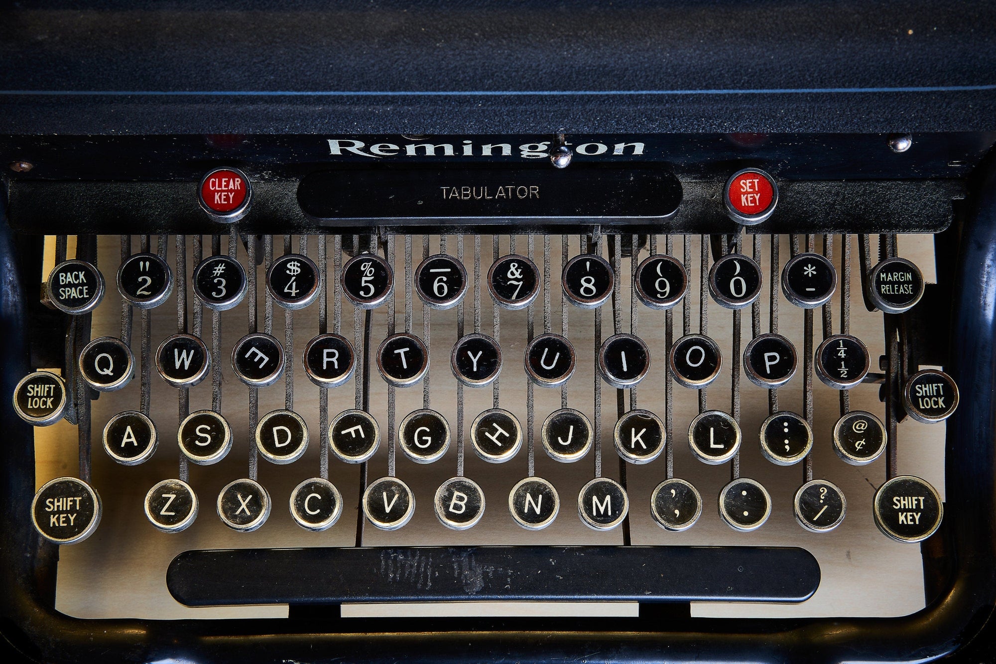 Close-up of a vintage typewriter keyboard with 'Remington Tabulator' branding and black keys all askew.