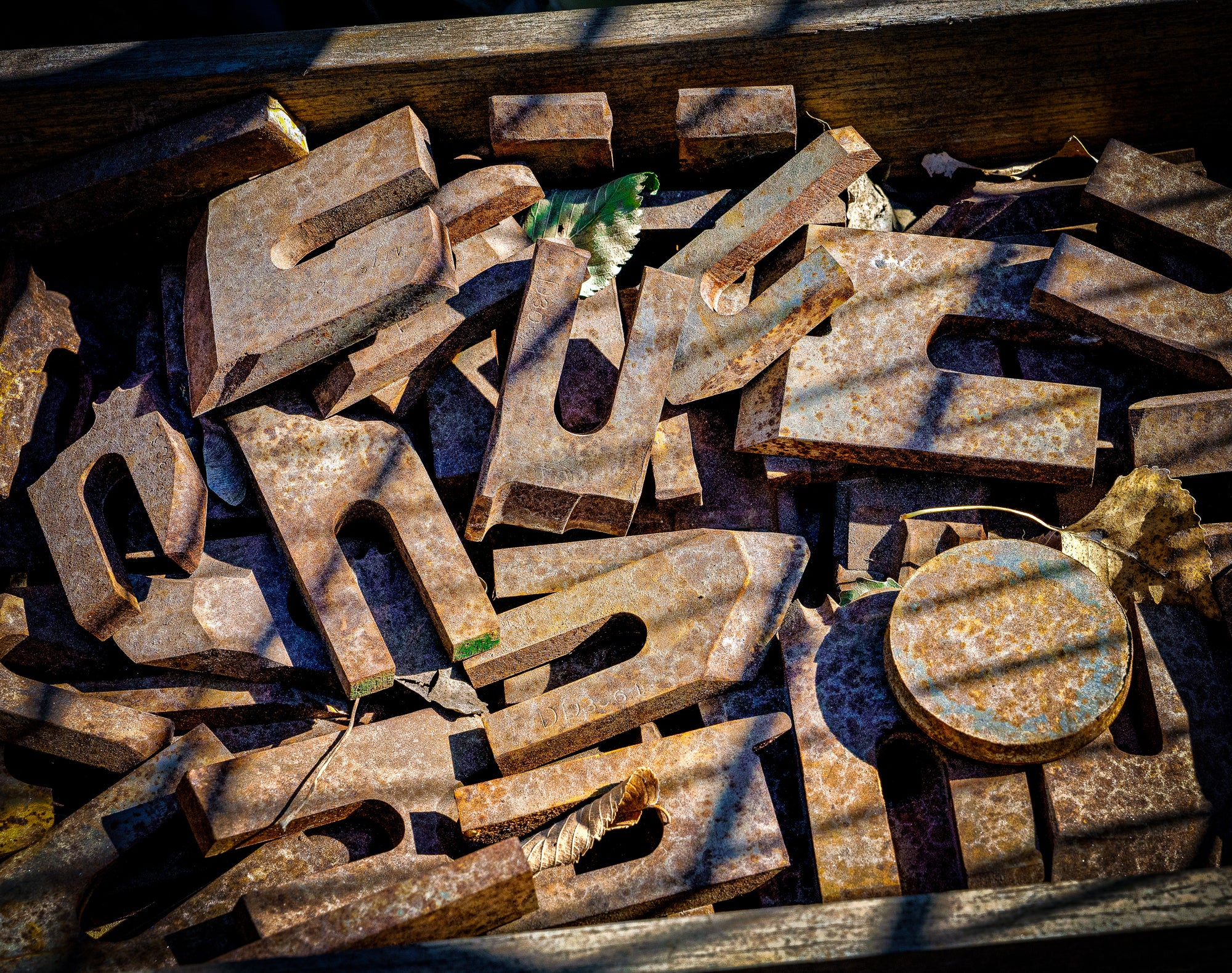 A pile of unidentified rusty metal shapes in sun and shadow; photographer Rick Graves