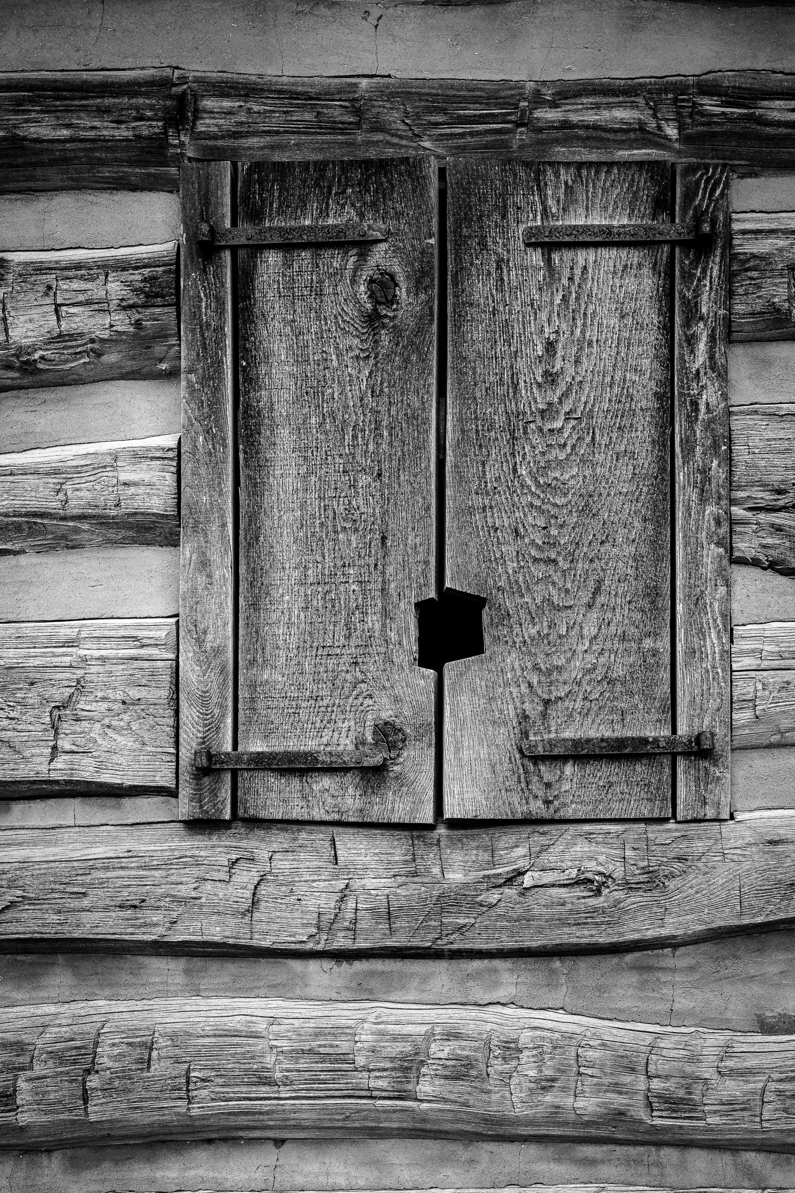 Close-up of wooden shutters on a log cabin wall; photographer Rick Graves