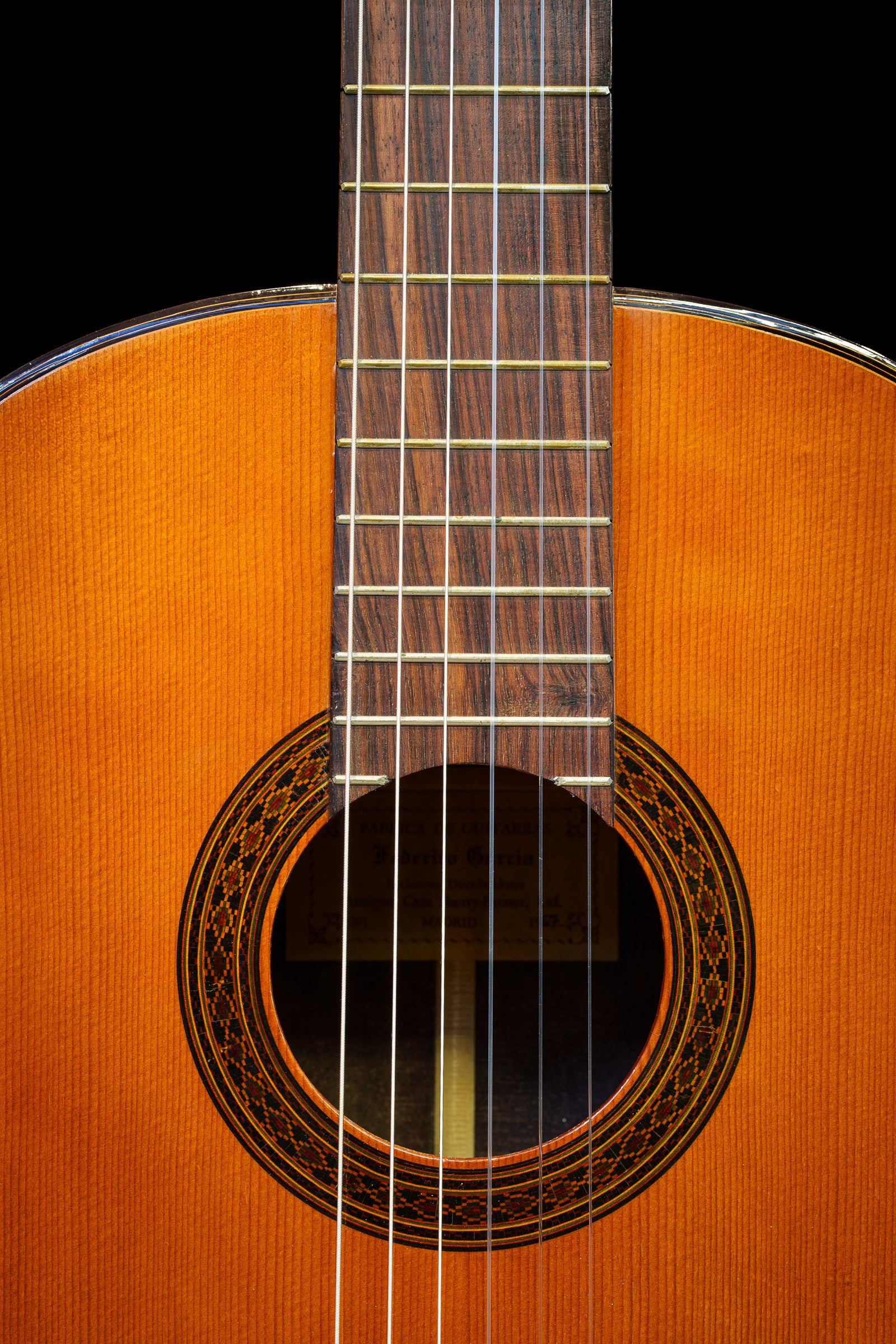 Close-up of a Federico Garcia classical guitar on a black background; photographer Rick Graves
