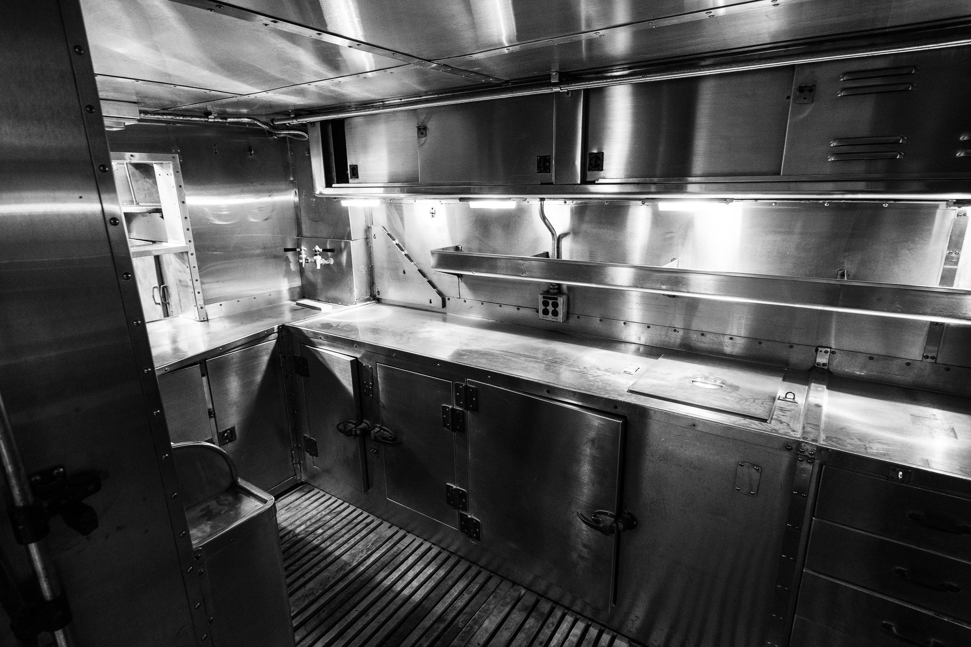 Vintage railroad galley kitchen with stainless steel cabinets and counters; photographer Rick Graves