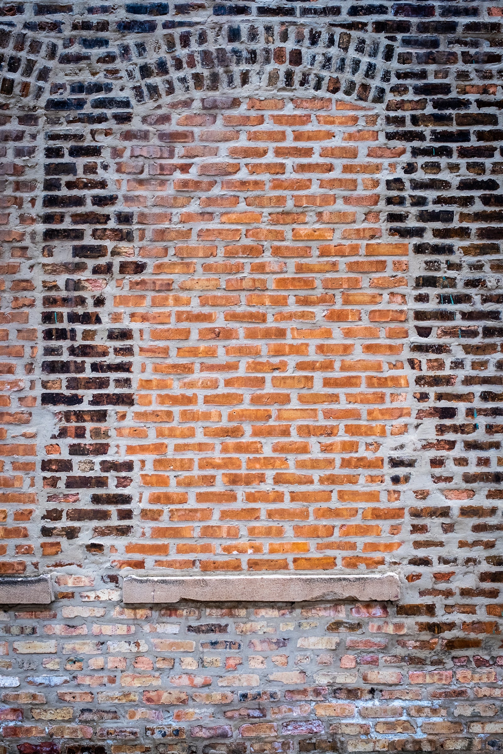 Old brick wall with a windows that have been bricked over; photographer Rick Graves