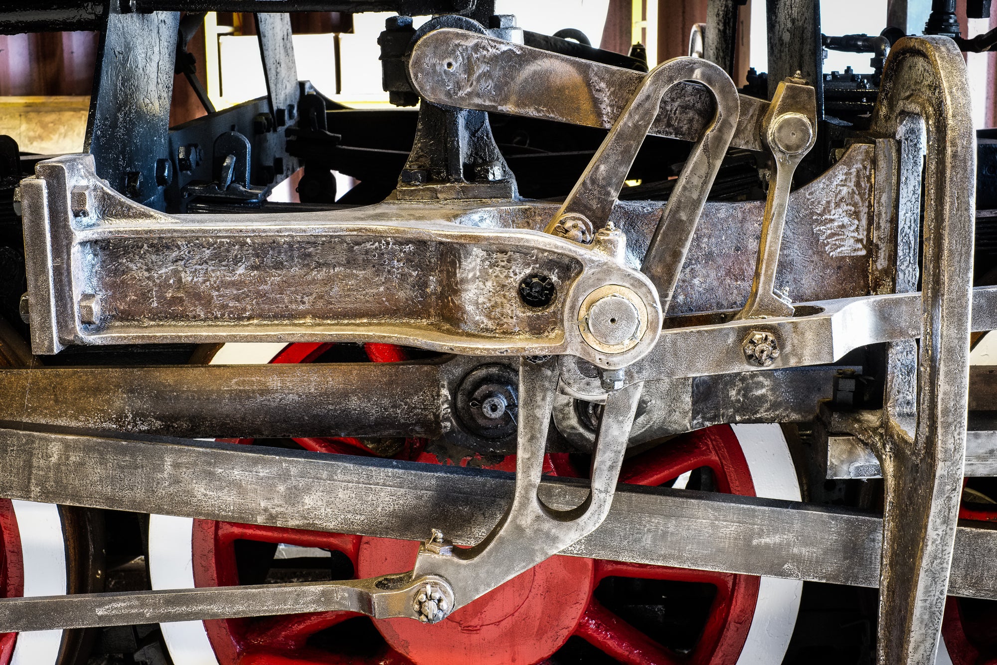 Close-up of mechanical components of a vintage locomotive with wheels painted red; photographer Rick Graves