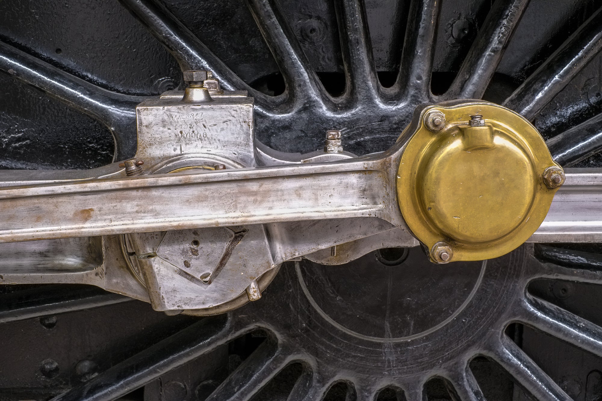 Silver drive shaft on a vintage locomotive with a gold-color component; photographer Rick Graves