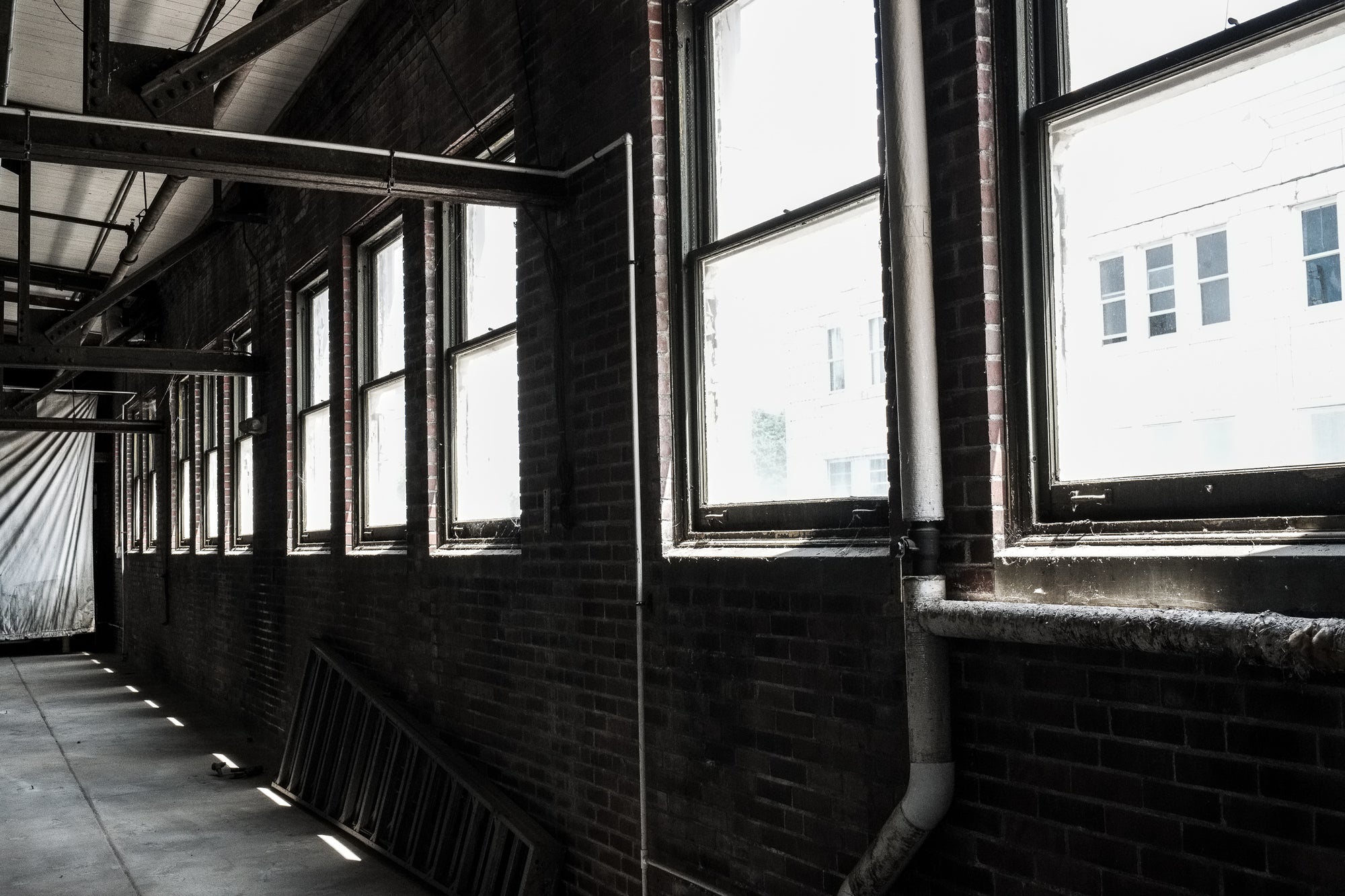Perspective shot of a brick wall with 11 large windows in a brick wall; photographer Rick Graves