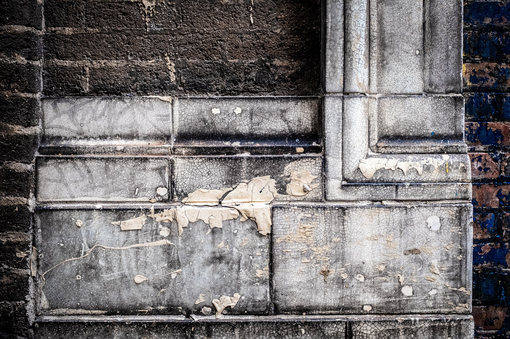 Weathered brick wall with peeling white paint; photographer Rick Graves