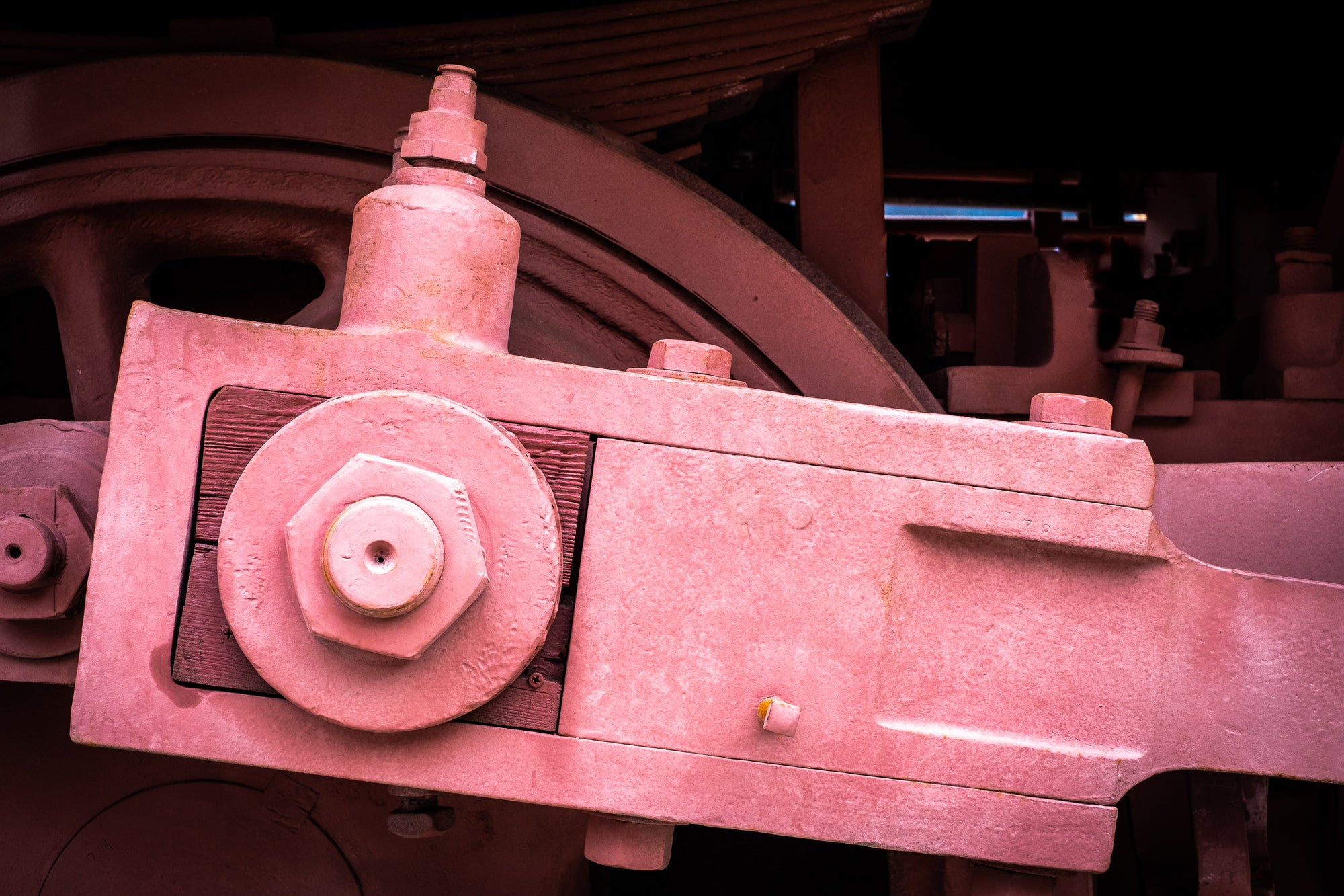 Railroad mechanical component with pinkish-red color preservative; shows a kluged piece of wood inset. Photographer Rick Graves