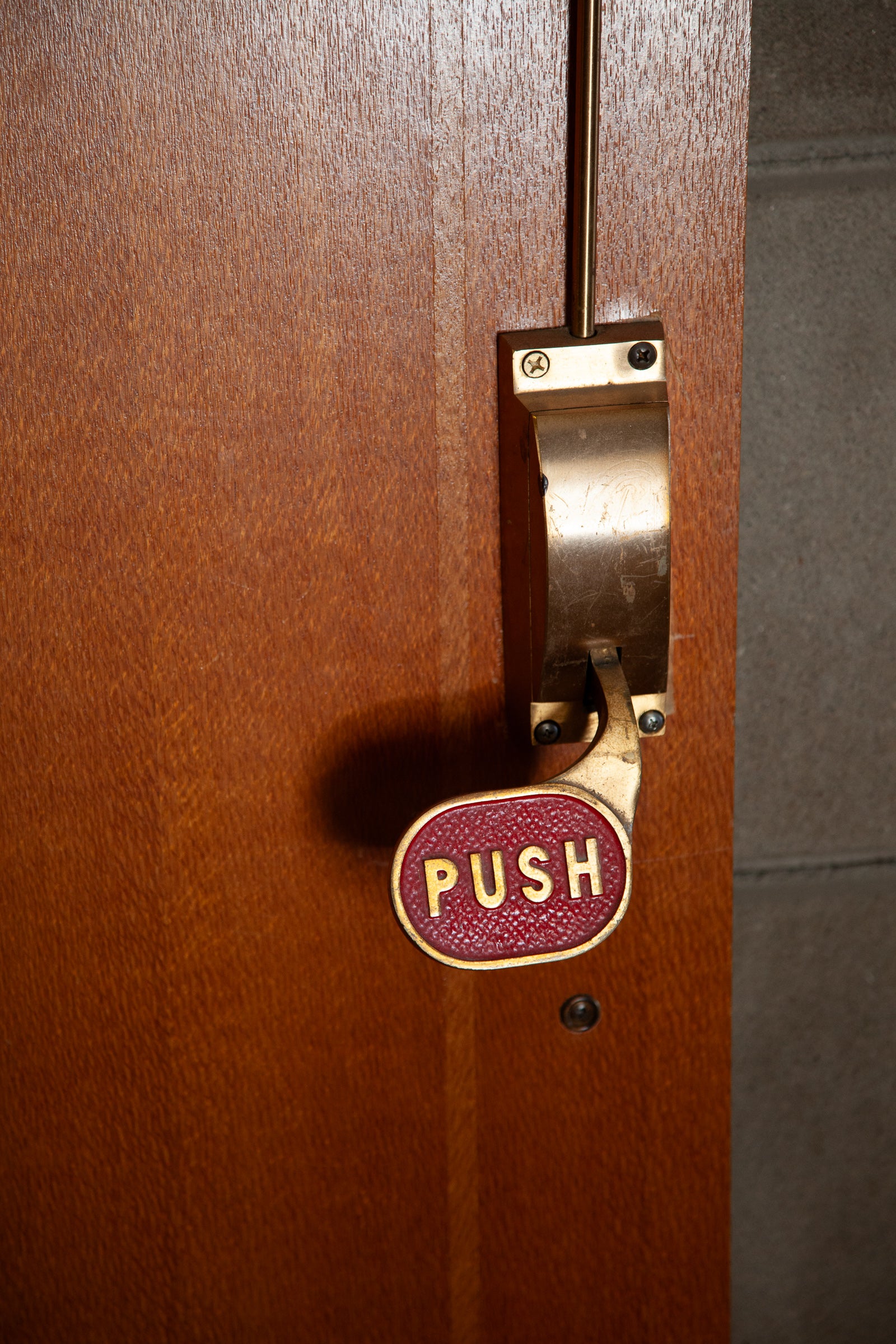 Wood door with metal hardware and a handle labeled 'PUSH'; photographer Rick Graves