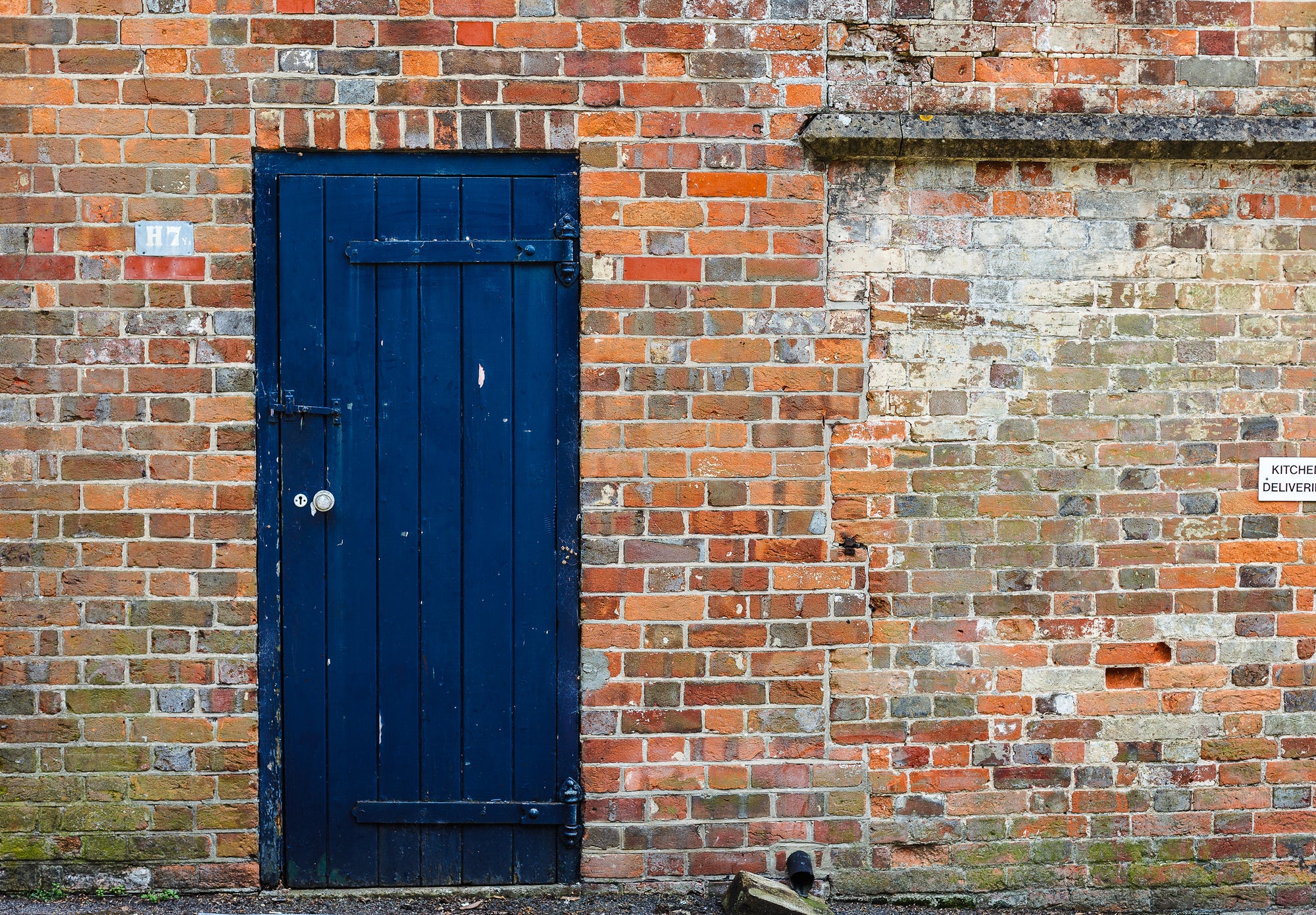 Blue door on a old brick wall with a Kitchen Deliveries sign; photographer Rick Graves