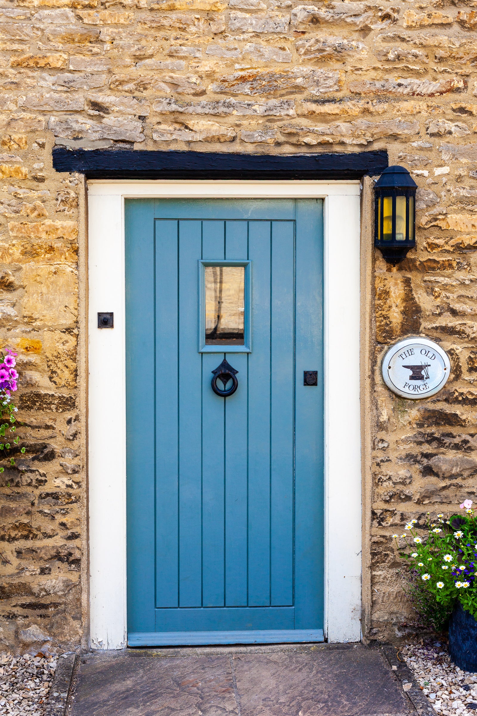 Blue door on a stone building with a lamp and sign; photographer Rick Graves