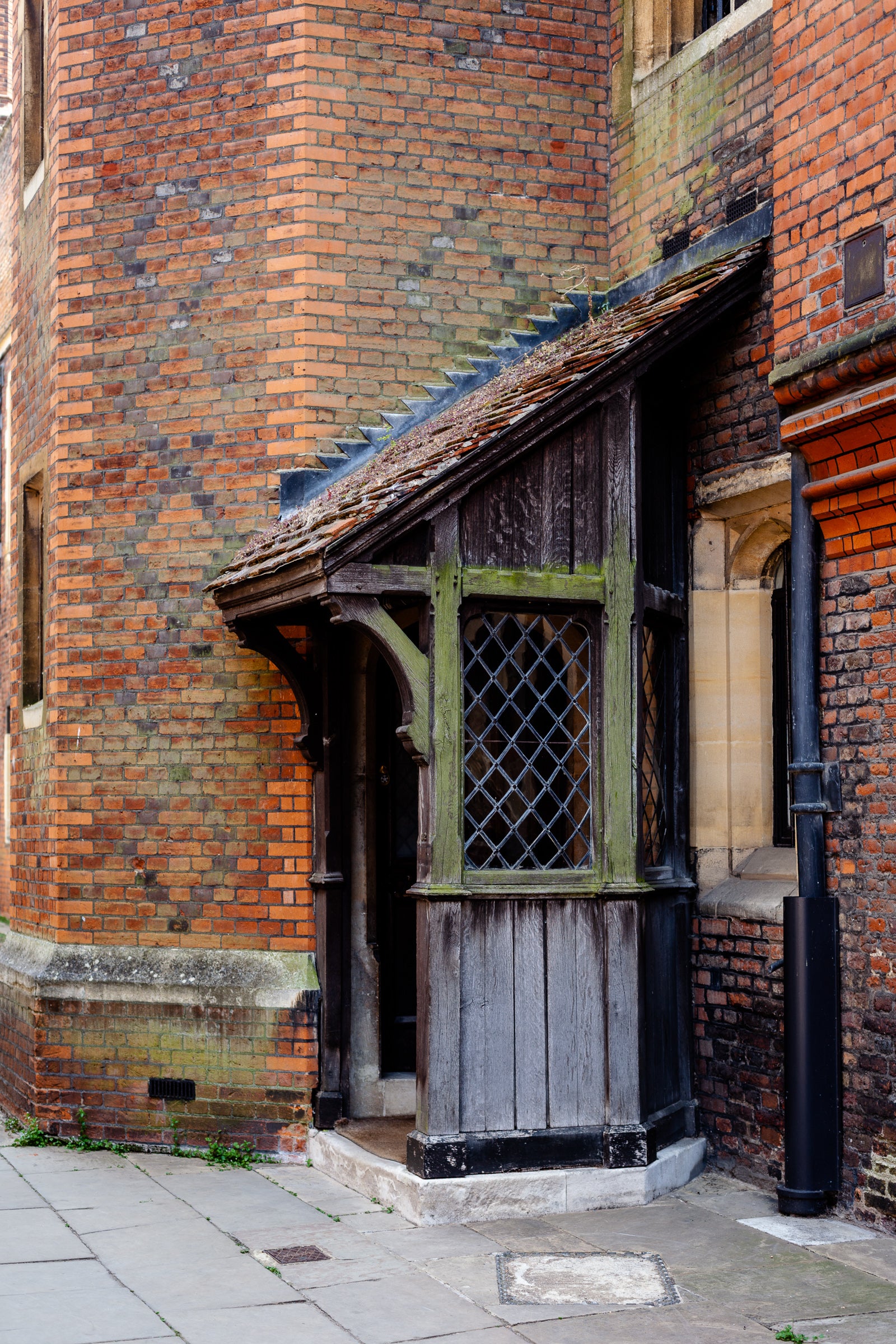 A very old wood doorway shelter added on to an even older brick building; photographer Rick Graves