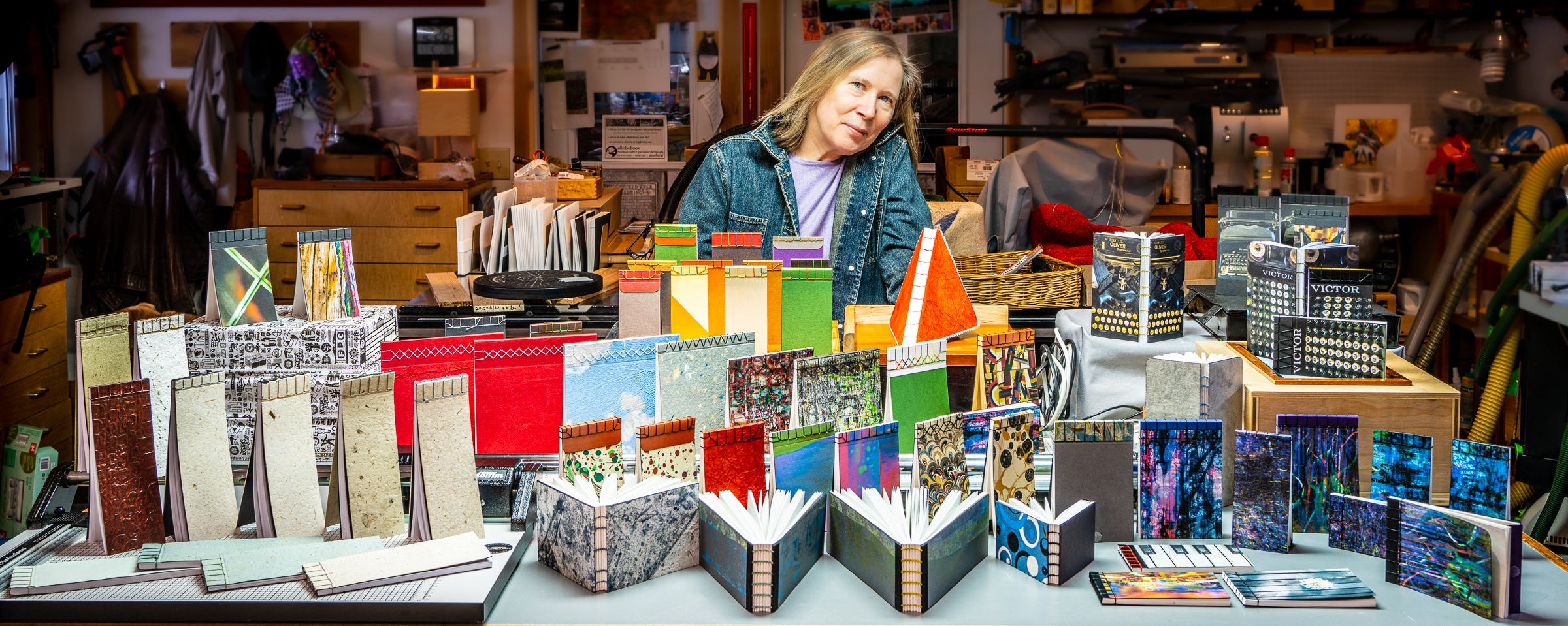 Joni in the workshop surrounded by several handmade books