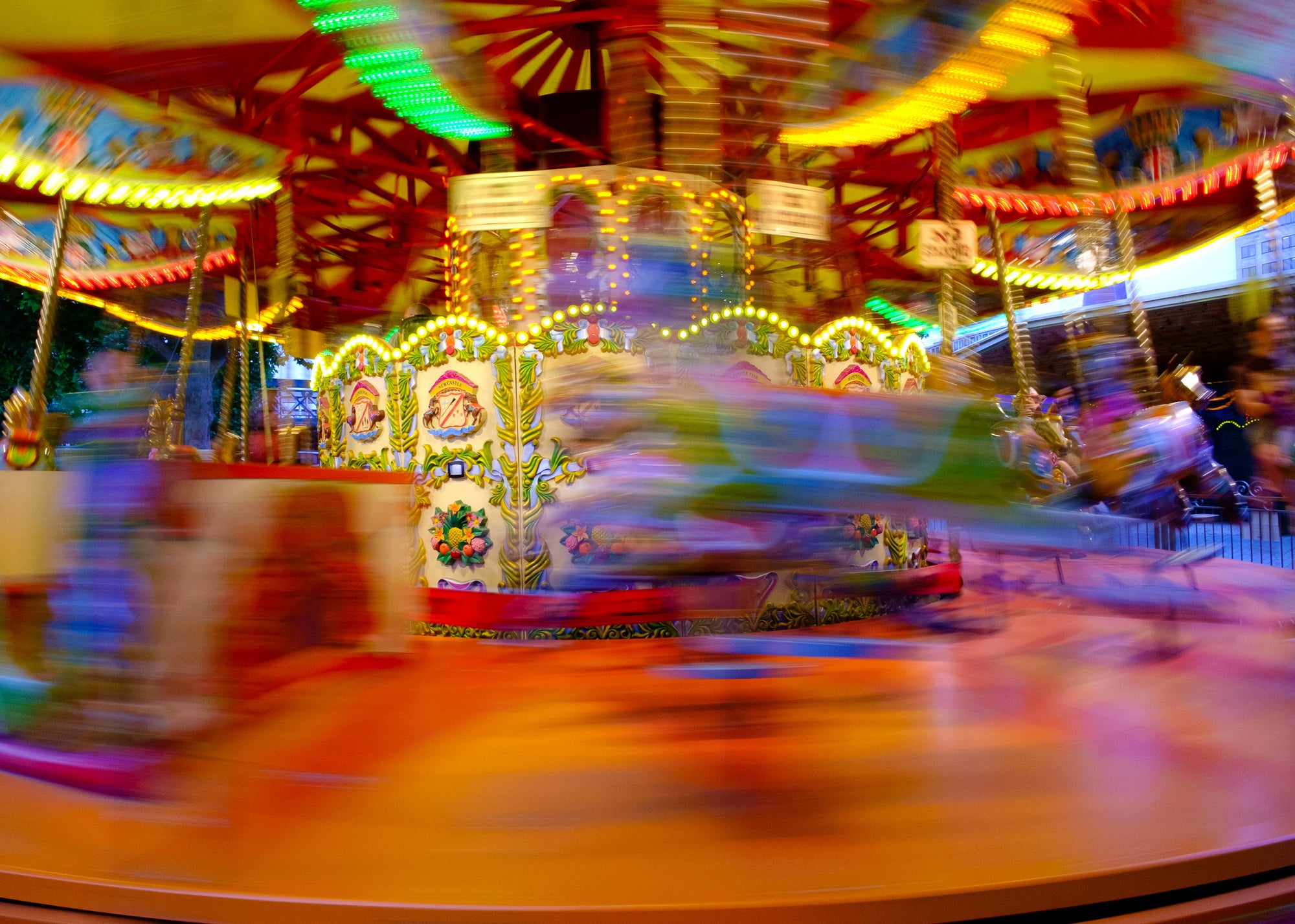 Blurred image of a colorful carousel in motion along the Thames in London — slow shutter, light and color unspooling. Rick Graves; every print $25 plus shipping.