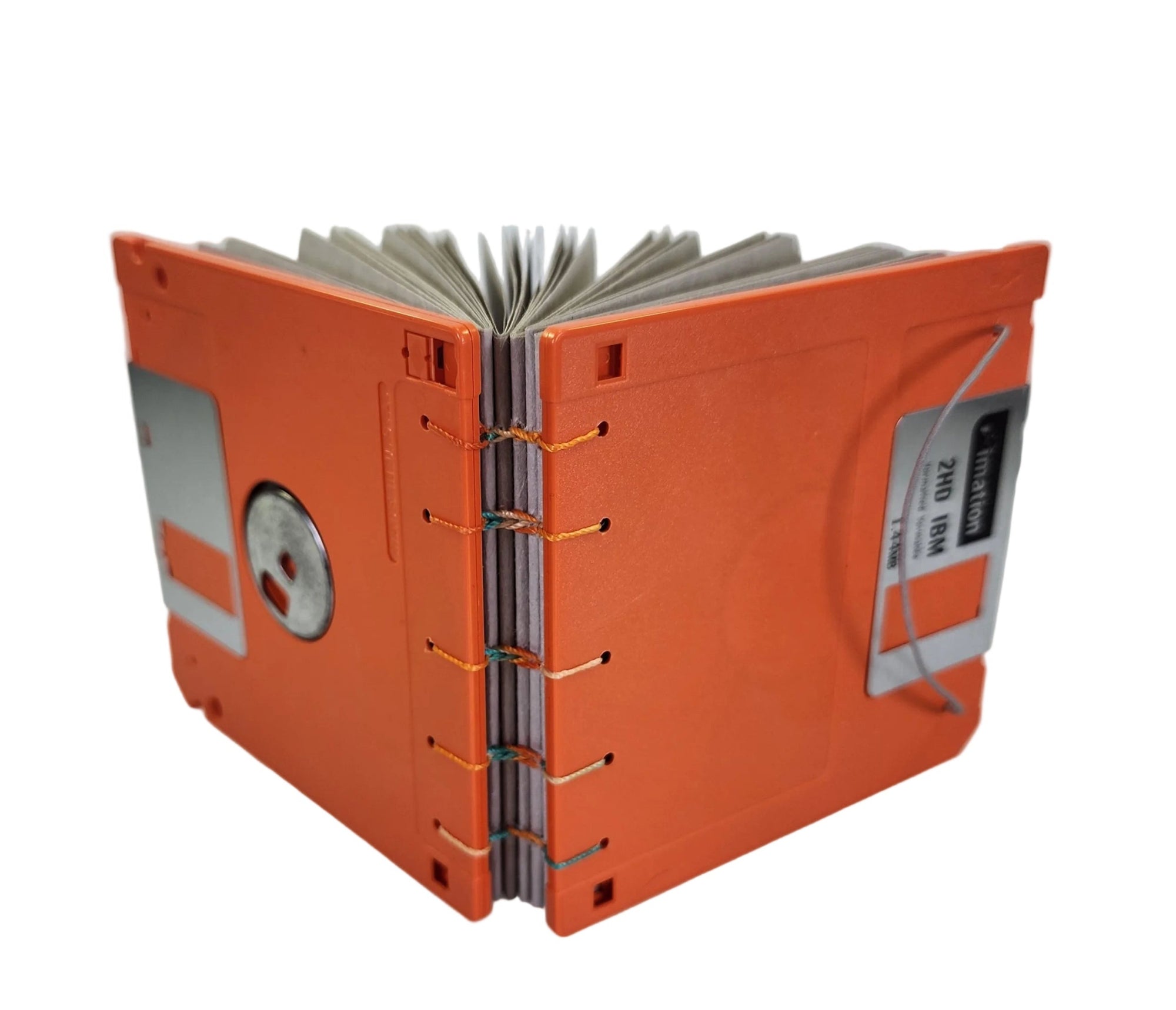 small handmade pocket notebook with orange vintage 1.44MB diskette covers bound with multi-color polyester thread, 3.5x3.5" 120 blank grey pages, shown on a white background