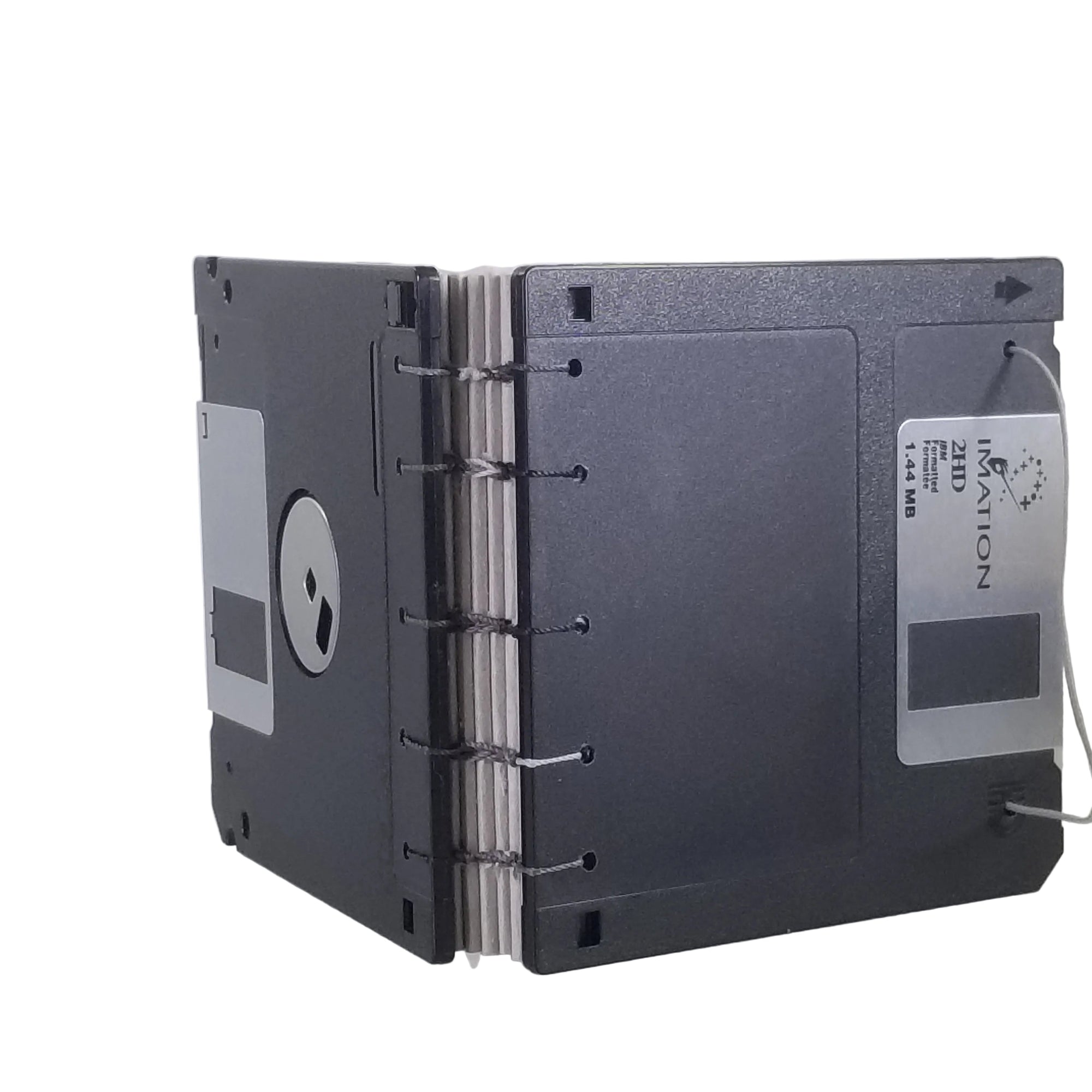small handmade pocket notebook with black vintage 1.44MB diskette covers bound with multi-color polyester thread, 3.5x3.5" 120 blank grey pages, shown on a white background
