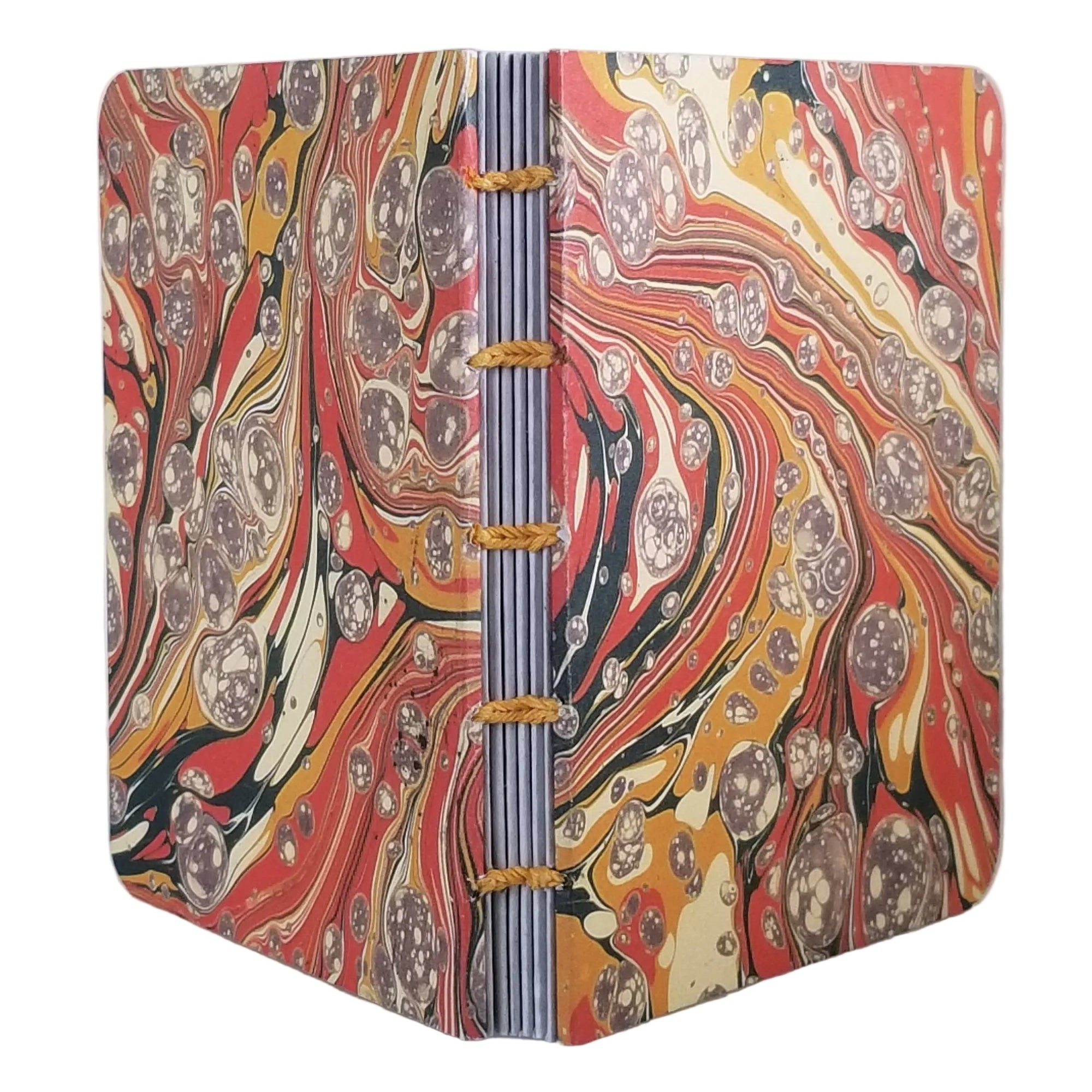 handmade coptic-bound blank notebook with multicolor printed marbled covers in oranges, gold, cream, and dark green, bound with golden yellow waxed linen thread, ~4x5.5" 96 pages, shown on a white background