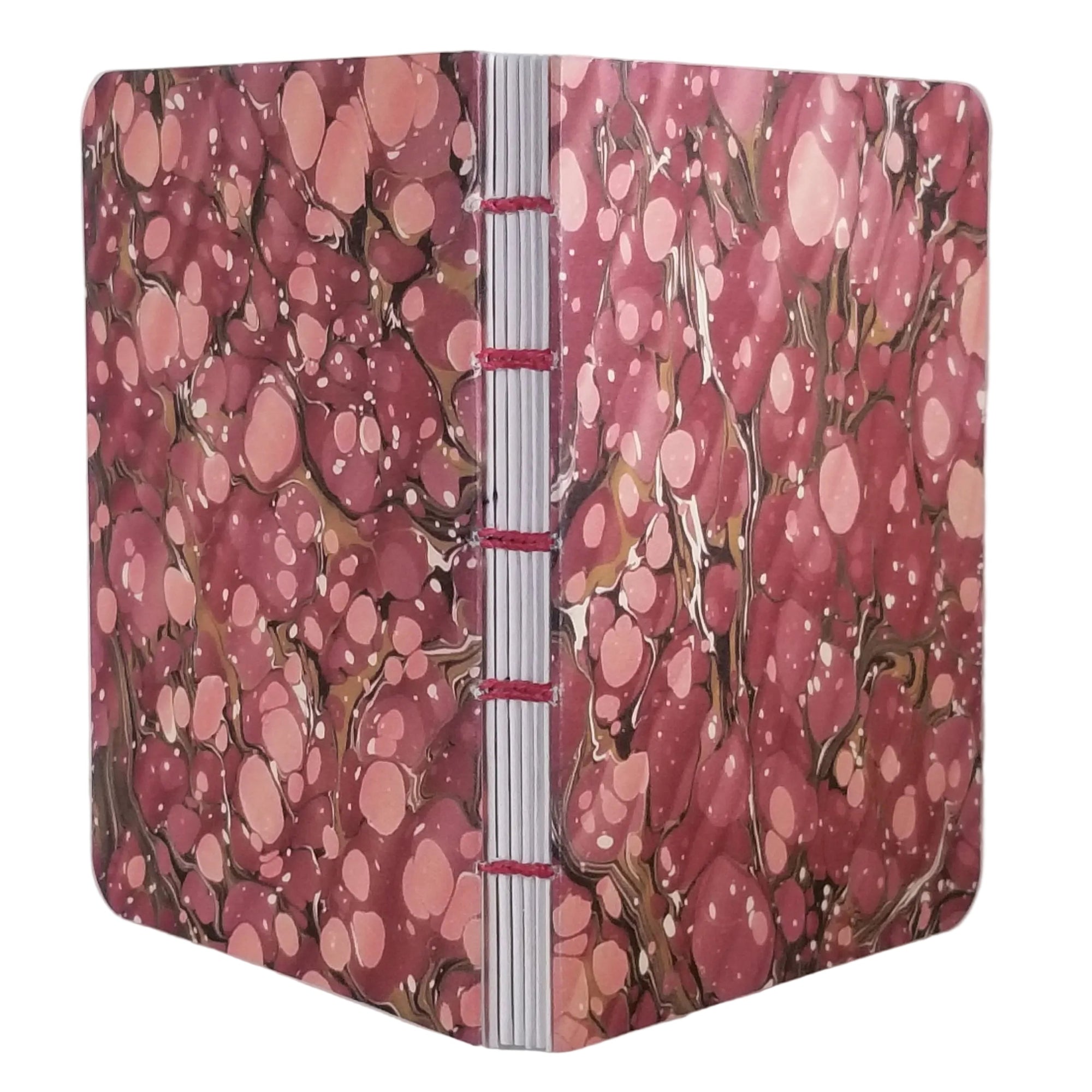 handmade coptic-bound blank notebook with multicolor printed marbled covers in dusty reds and mauve, bound with matching red waxed linen thread, ~4x5.5" 96 pages, shown on a white background