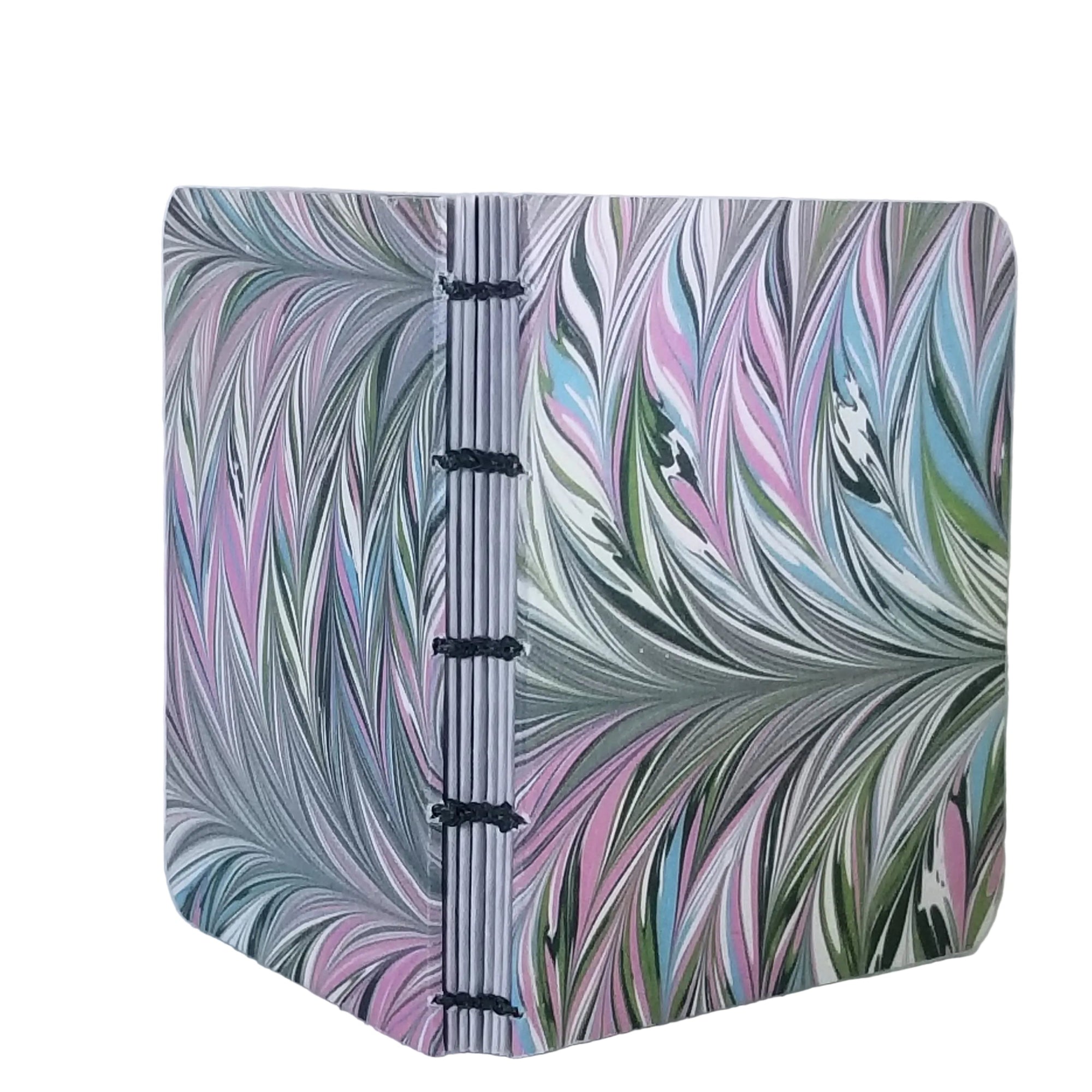 handmade small blank journal with predominantly green and pink printed paper marbling pattern, exposed spine, and dark green thread, ~4x4.25 96 pages, shown on a white background