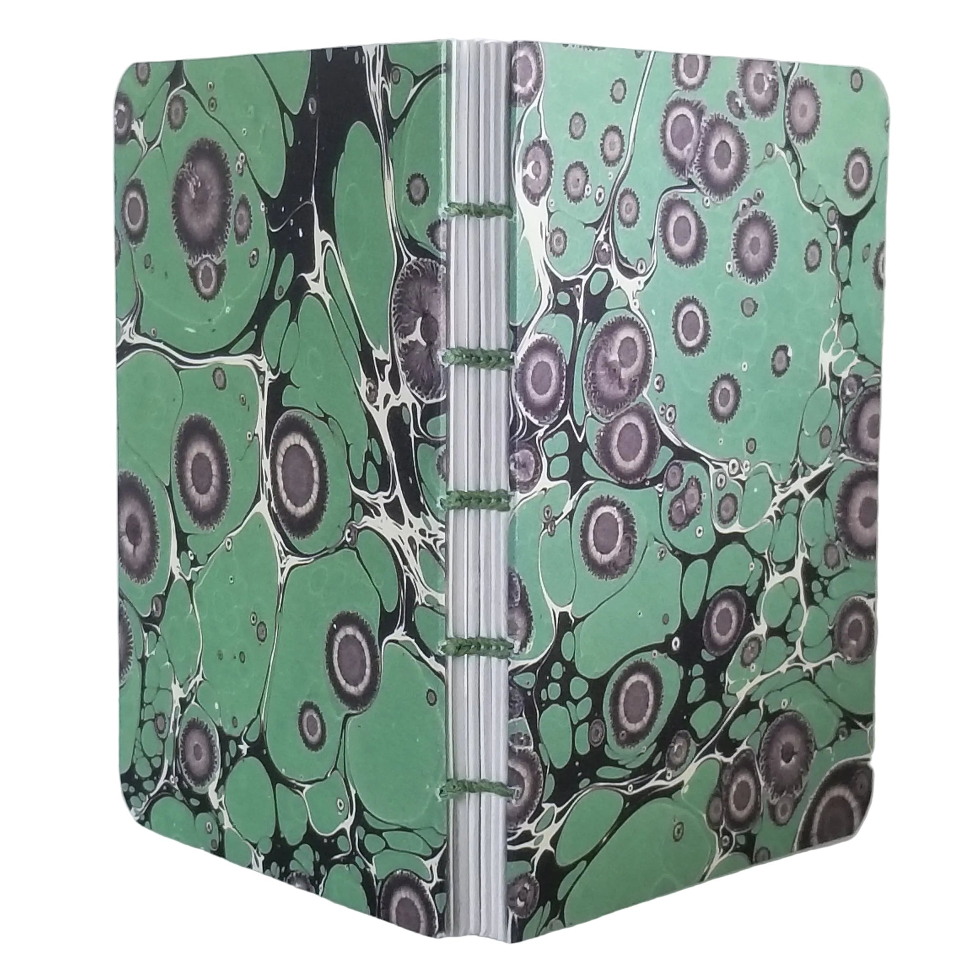 handmade small blank journal with a printed marbling pattern in green and black, exposed spine, and coptic binding with green waxed linen thread, ~4x5.5" 96 pages, shown on a white background 