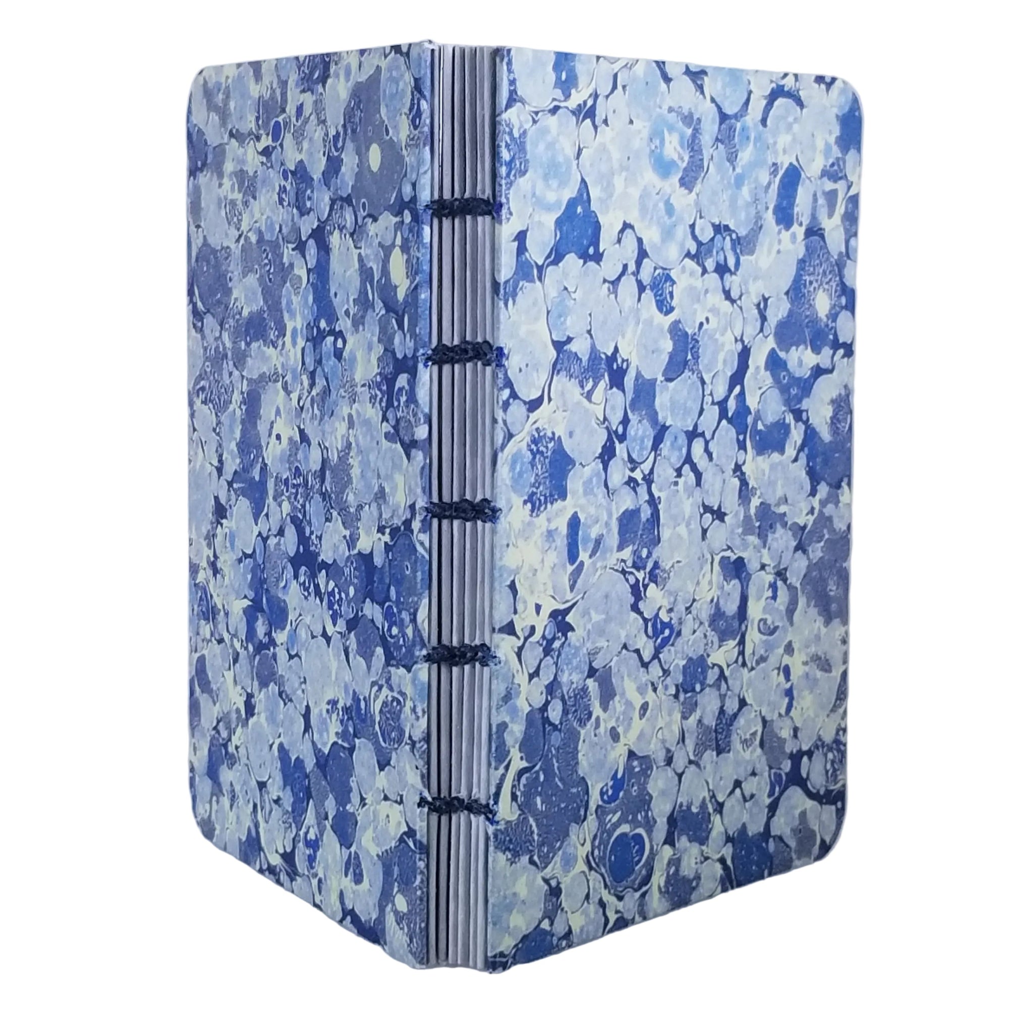 handmade small blank journal with predominantly blue and white printed marbling pattern, exposed spine, and blue linen thread, ~4x5.5" 96 pages, shown on a white background