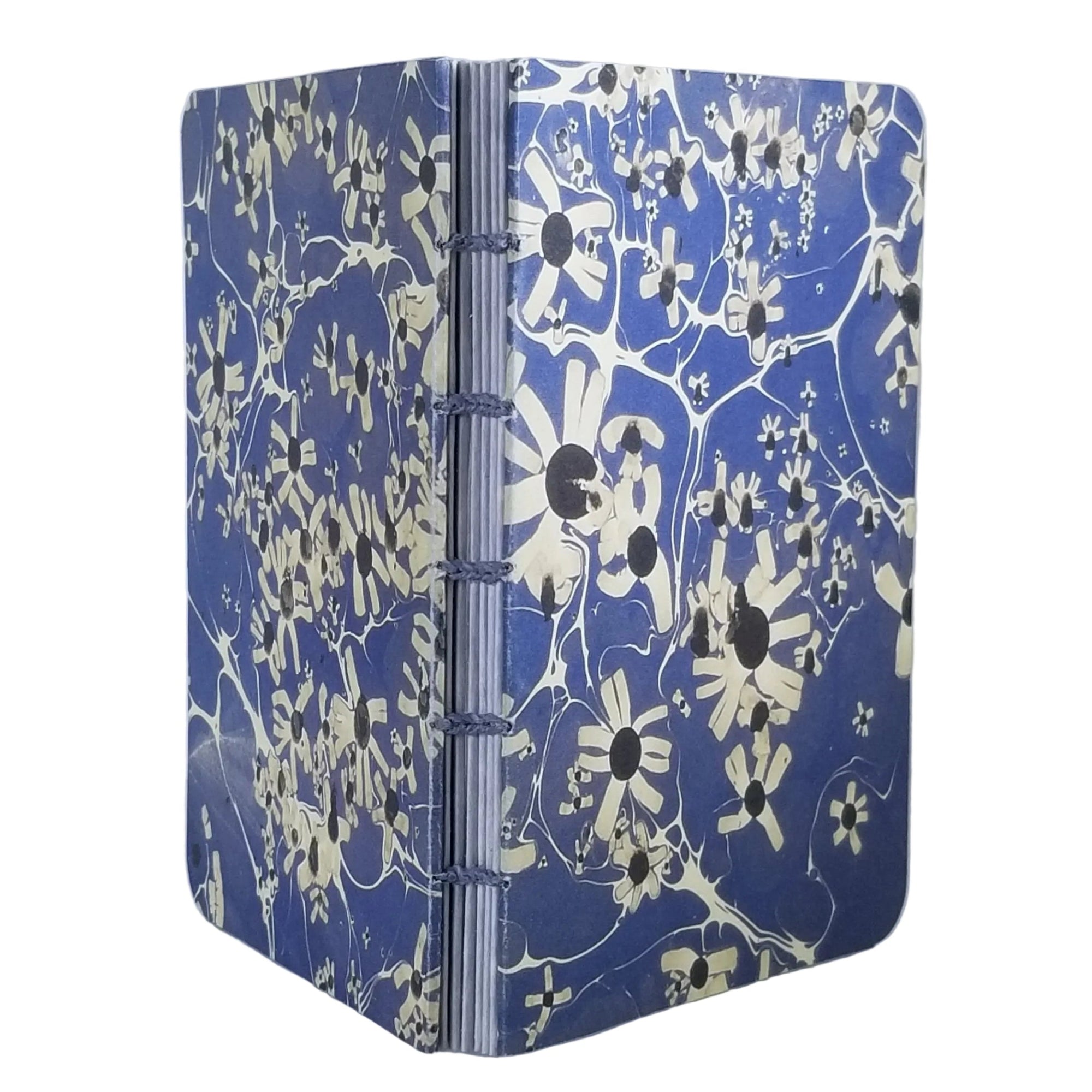 handmade small blank journal with predominantly blue and cream printed paper marbling pattern, exposed spine, and light blue thread, ~4x5.5" 96 pages, shown on a white background
