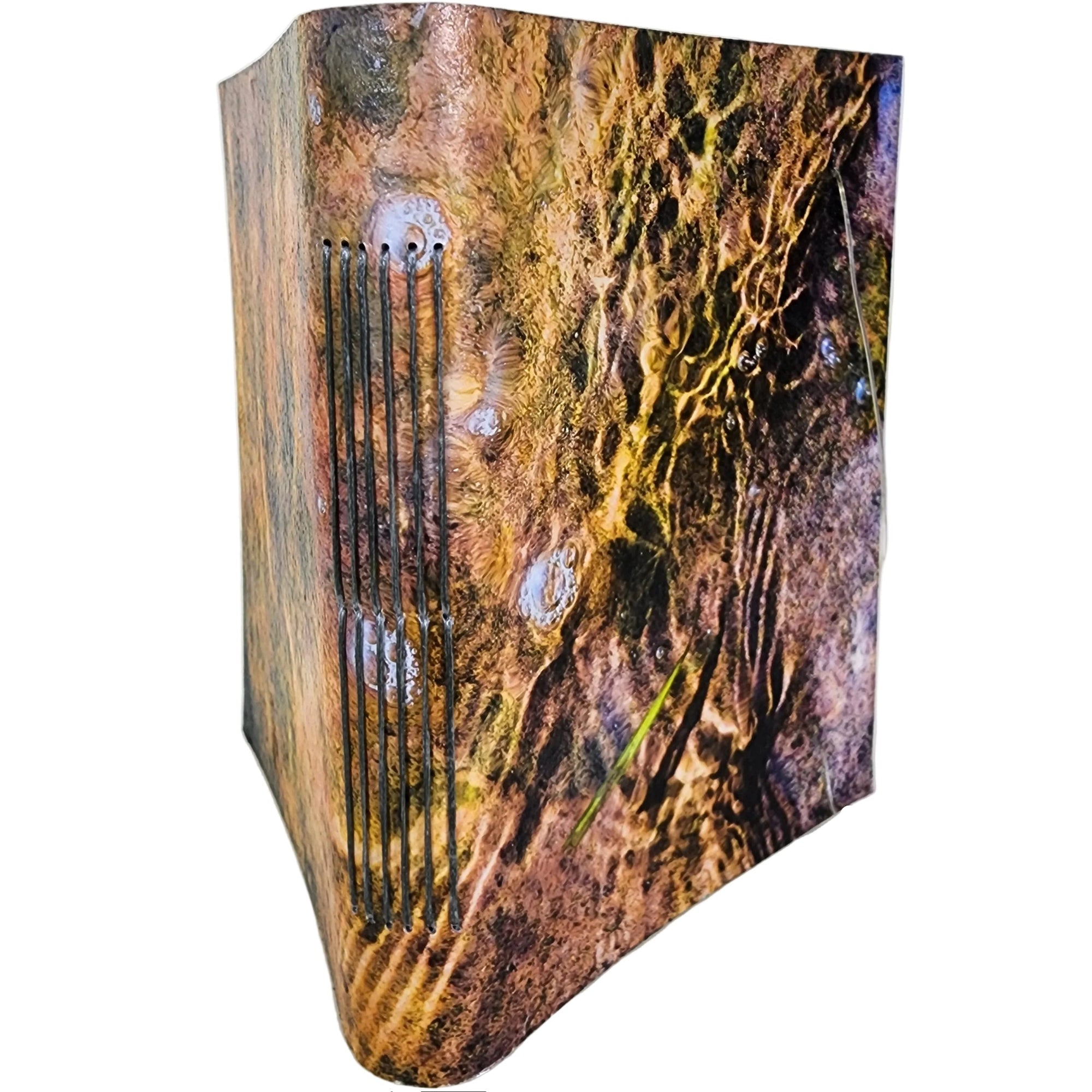0385 photowrap journal, image of ripples over rocks, grey longstitch binding, coated cover, clear elastic closure